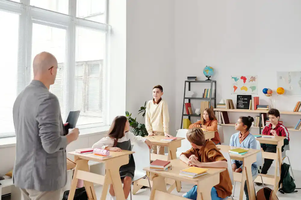 Students and a teacher having an active discussion in a modern classroom