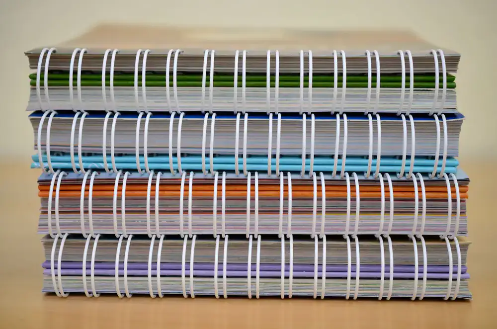 Language learning books and notebooks stacked on a desk
